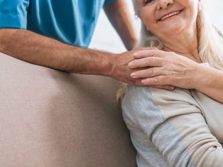cropped shot of smiling senior woman holding hand of caregiver